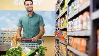 Portrait of smiling man walking in aisle with his trolely at supermarket Portrait of smiling man walking in aisle with his trolely at supermarket